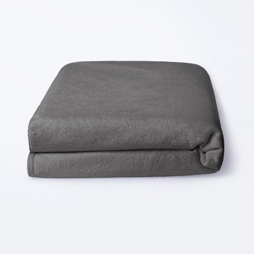 Grey fitted waterproof terry mattress protector shown on a 75 by 48 inch bed